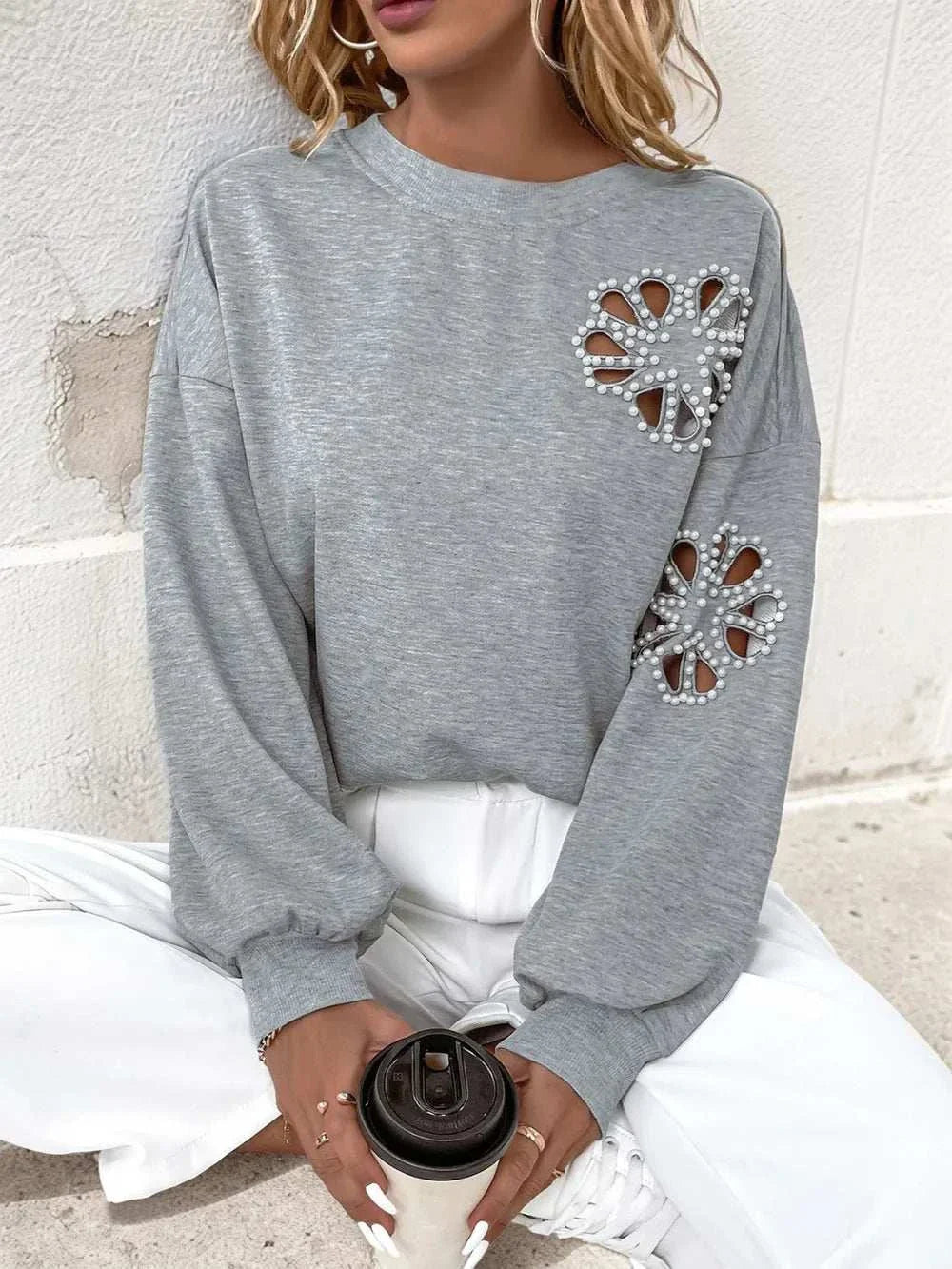 Gray long sleeve sweatshirt with round neck, cutout and pearl embellishments, slightly stretchy polyester fabric.