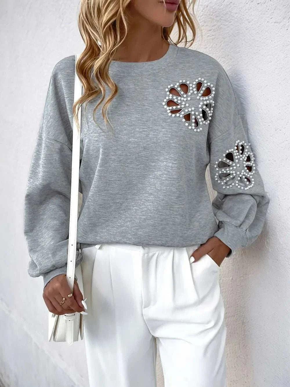 Gray long sleeve sweatshirt with pearl cutout details on chest and sleeve