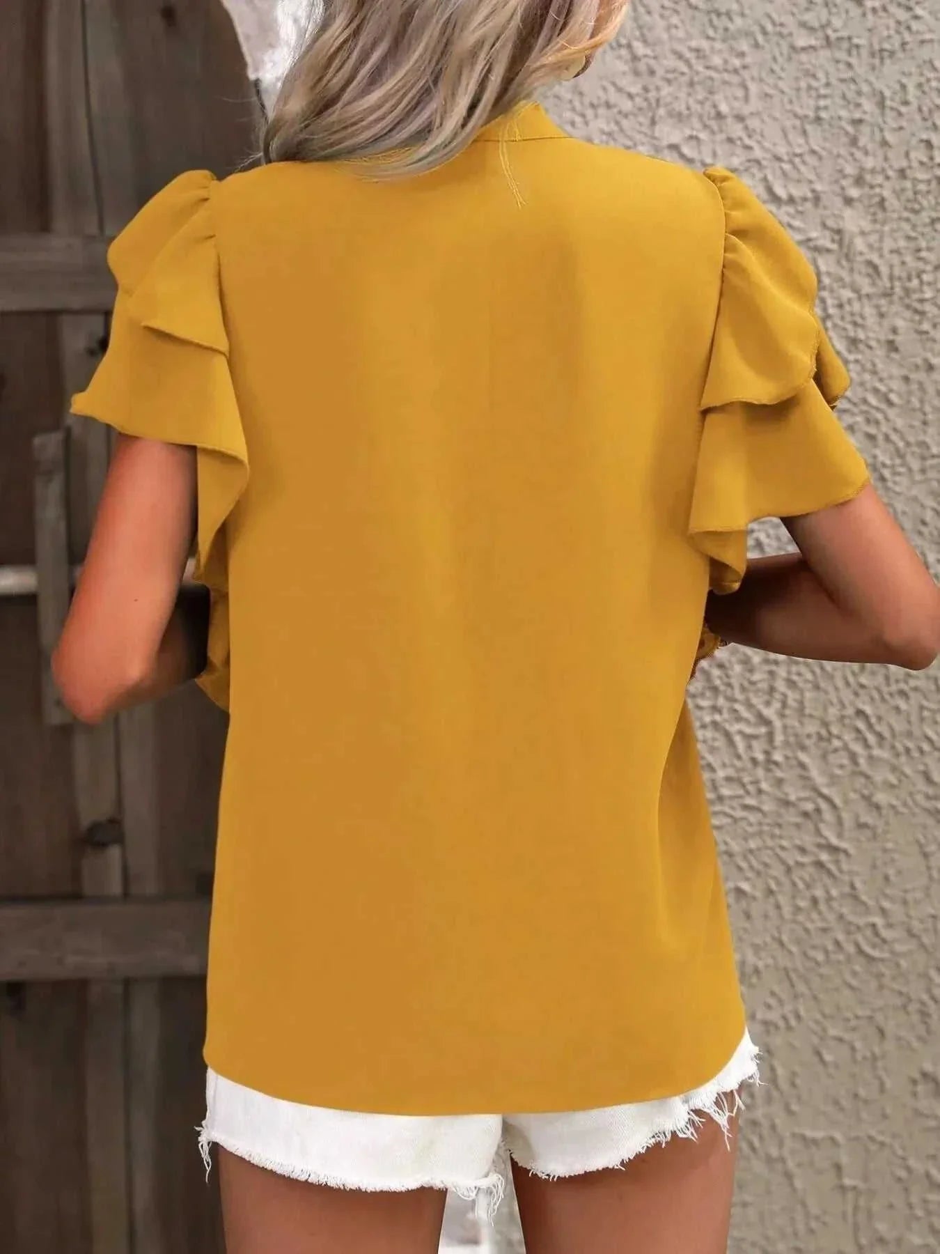 Mustard yellow ruffle sleeve notched blouse made of 100% polyester with no stretch and short layered sleeves.
