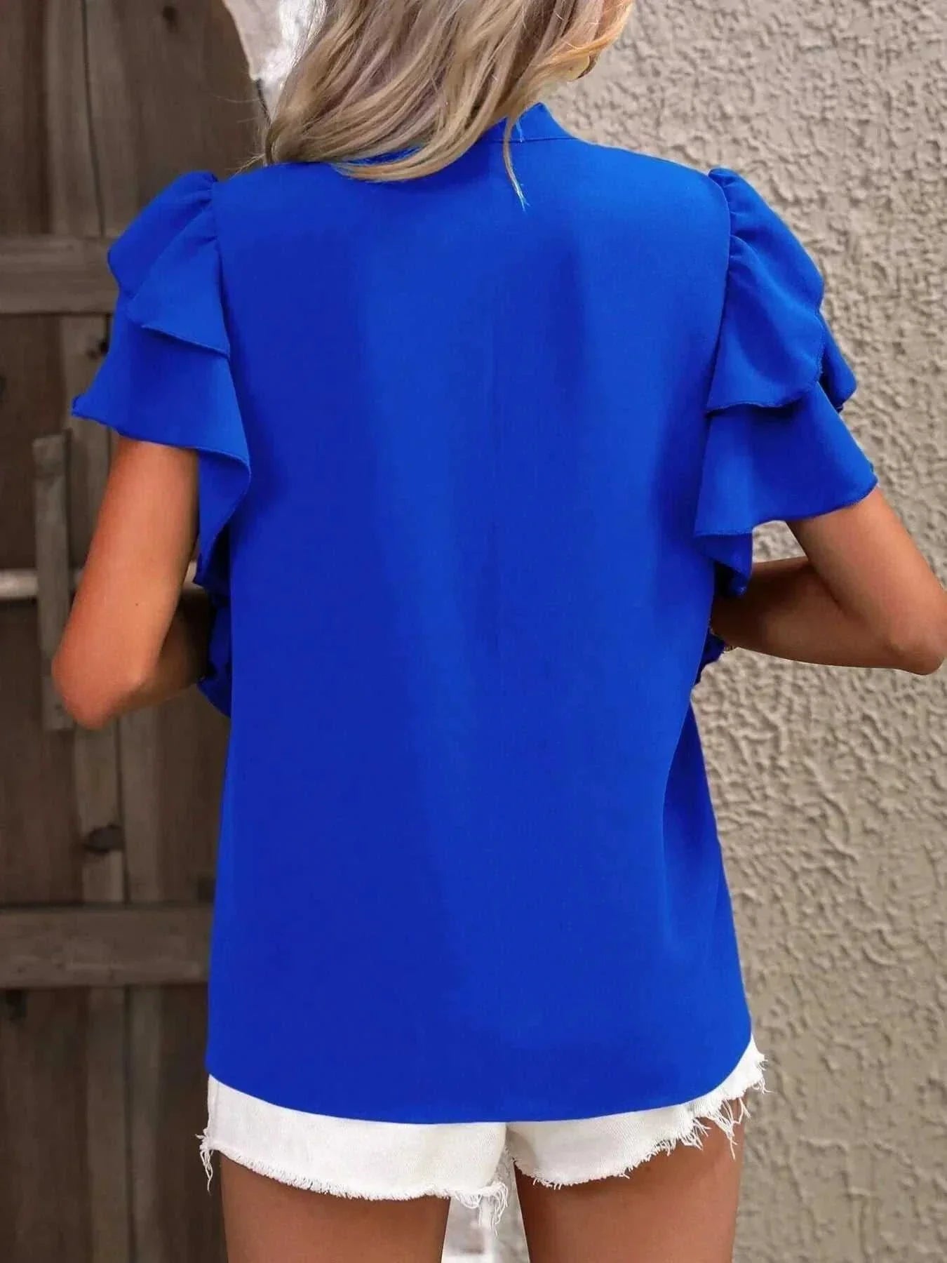Blue ruffle sleeve notched blouse made of 100% polyester with layered sleeves and no stretch.