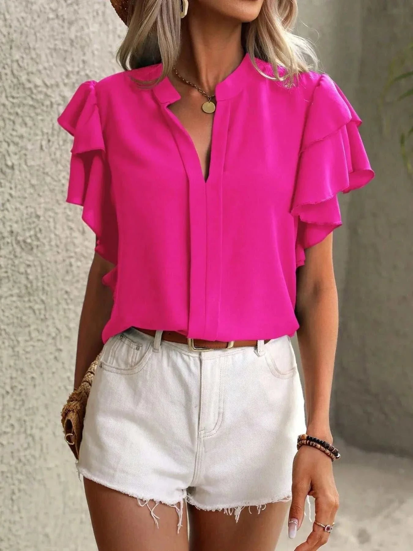 Pink ruffle sleeve notched blouse with v-neck and relaxed fit paired with white denim shorts