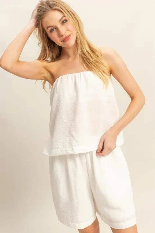 Woman wearing white HYFVE tube top and flowy shorts set with relaxed fit and casual style