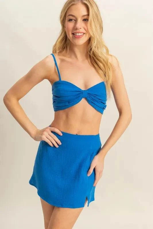 Blue HYFVE ruched bra top and mini skirt set worn by woman with slit detail on skirt