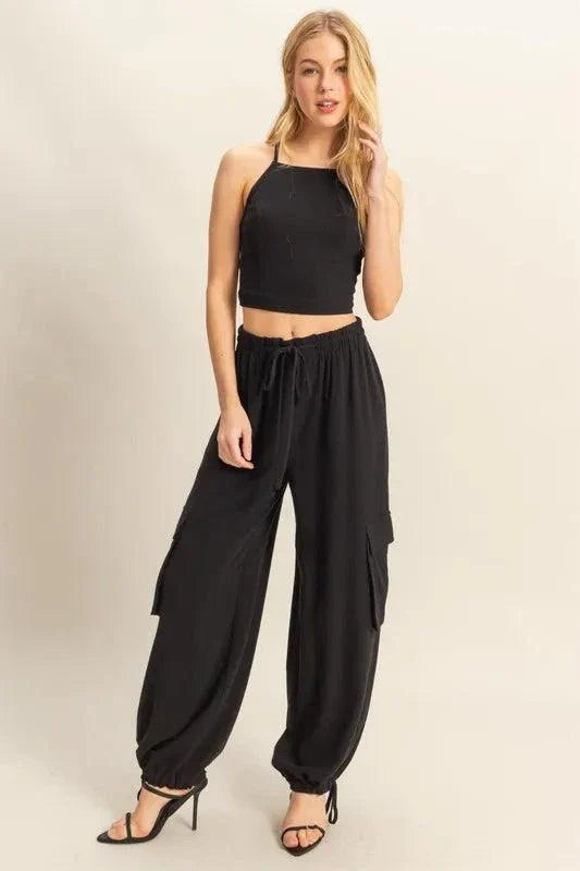 Woman wearing black HYFVE crop top and cargo pants set with drawstring and pockets