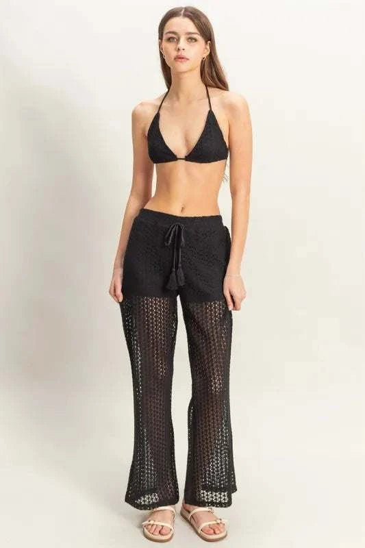 Woman wearing a black HYFVE Crochet Bra and wide-leg drawstring pants beach cover up set.