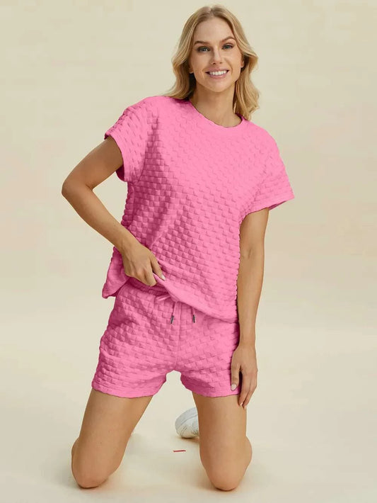 Woman wearing pink Double Take Full Size textured t-shirt and shorts set with drawstring