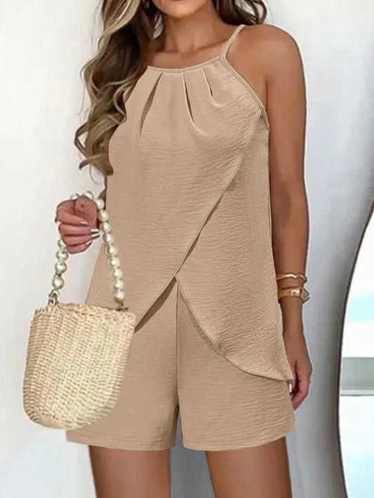 Woman wearing beige spaghetti strap top and shorts set with a woven handbag and gold bracelet accessories