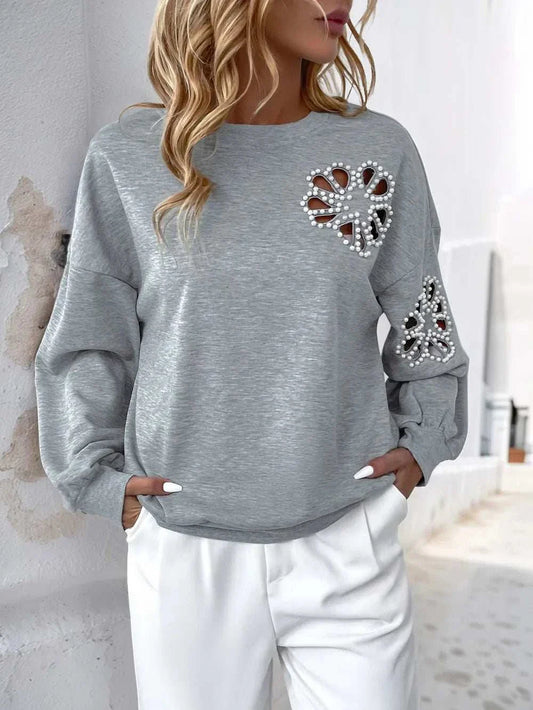 Grey long sleeve sweatshirt with cutout pearl embellishments on chest and sleeve, round neck design