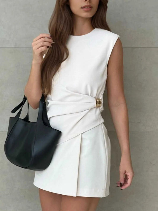 Woman wearing white round neck sleeveless top and matching skirt set with black handbag
