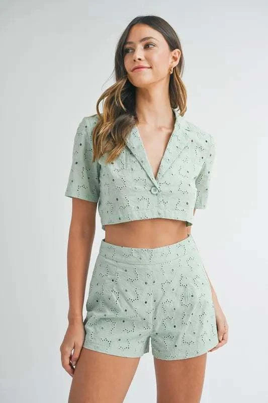 Woman wearing light green eyelet short sleeve crop top and matching shorts set